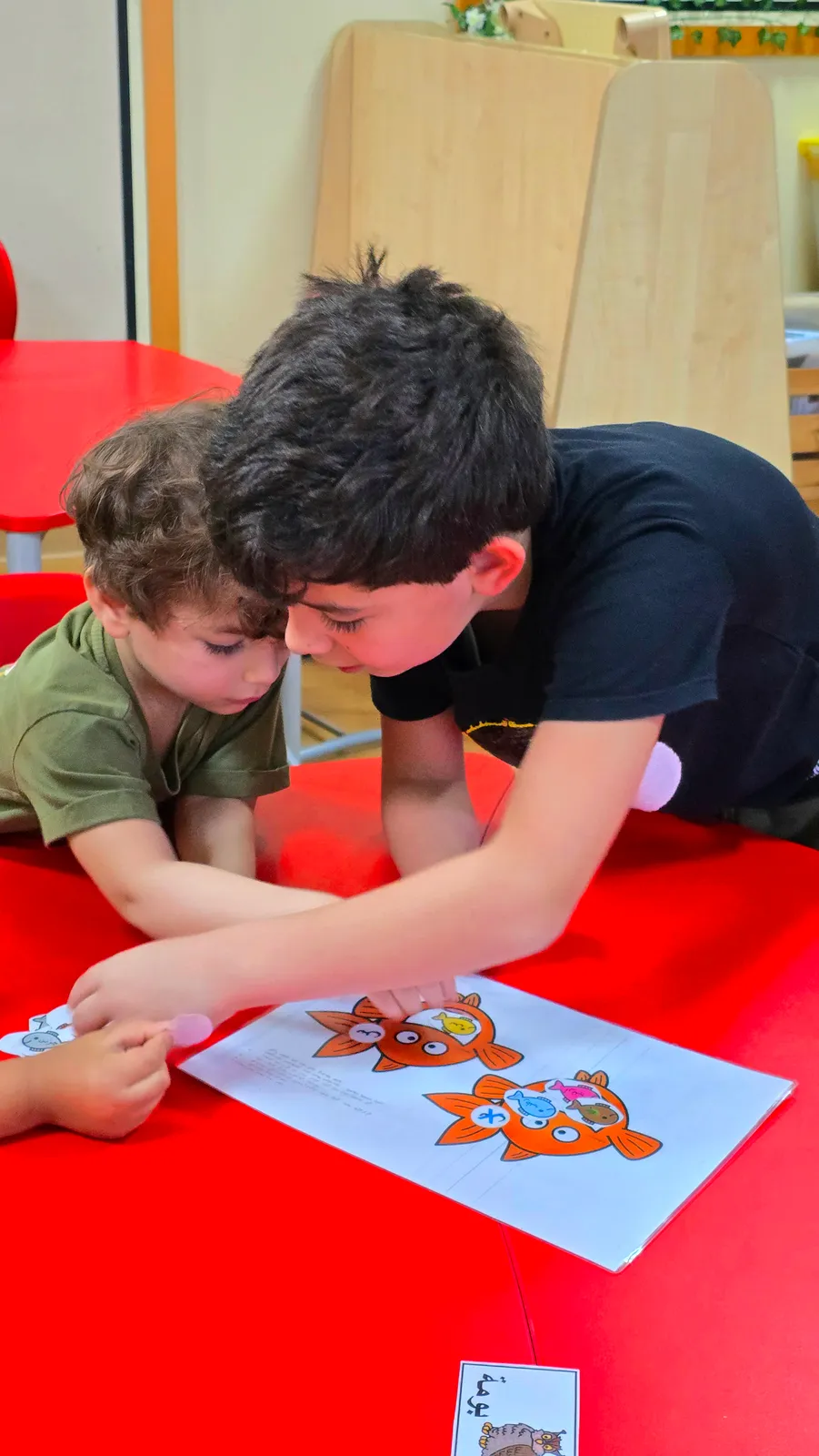 Two children playing a card game together